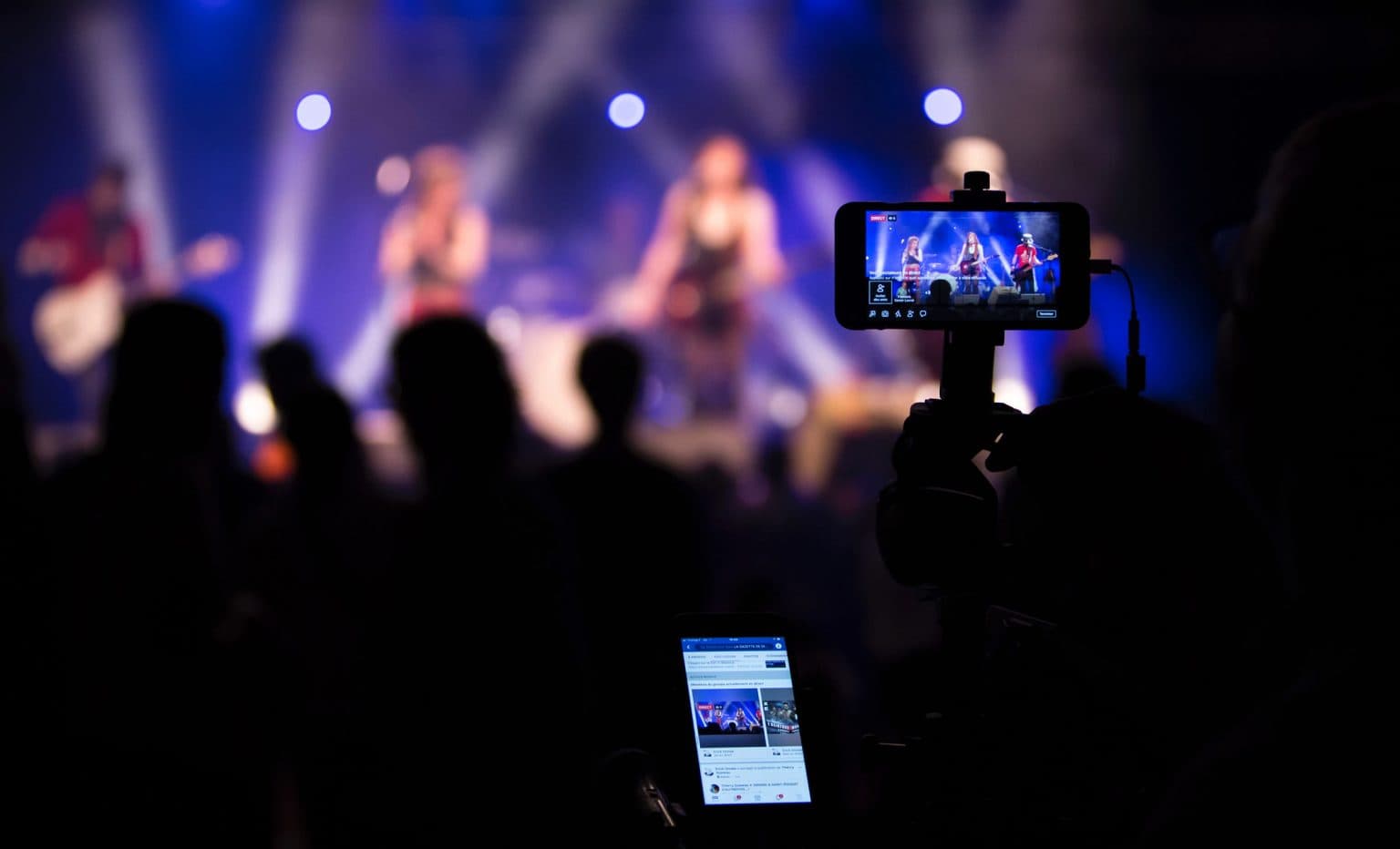 Concert being live streamed on a smartphone mounted on a camera rig in the crowd